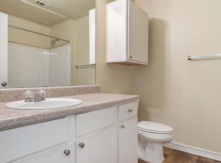 Bathroom with white cabinets and extra storage above the toilet